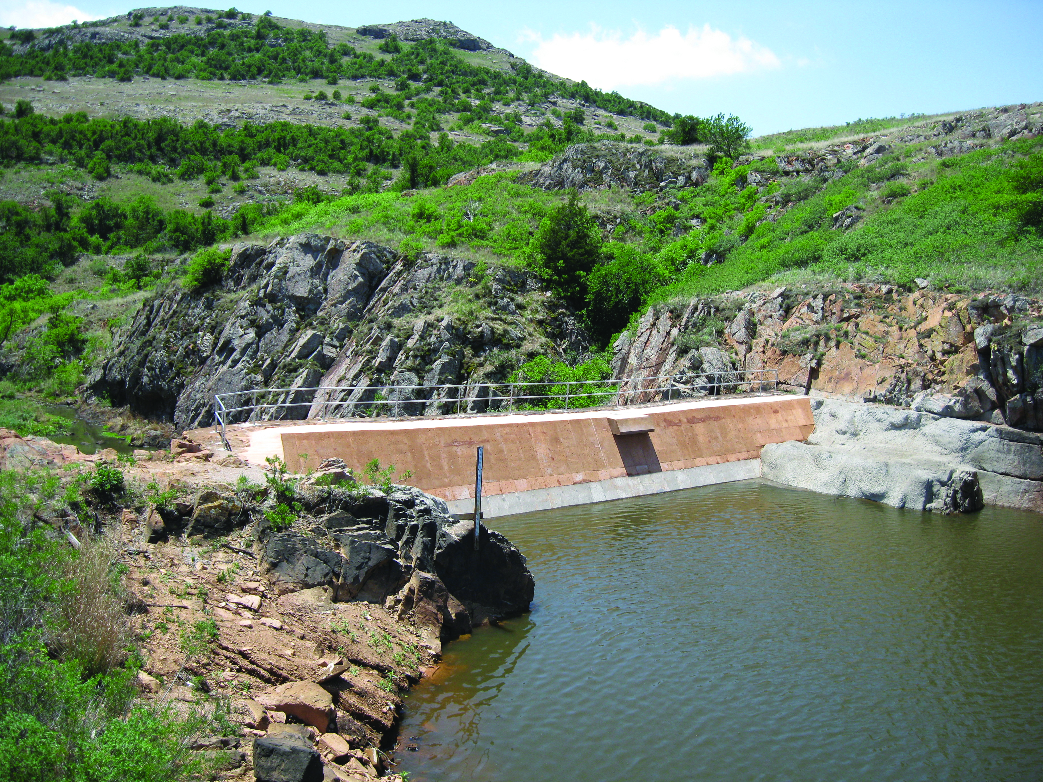 A dam utilizing a crystalline waterproofing admixture that helps to produce watertight concrete structures that come in regular contact with water.